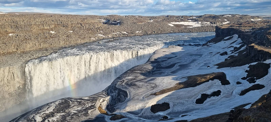 Slap Dettifoss na severu Islandije, največji in najmočnejši slap v Evropi, kjer ogromna količina vode pada v globoko sotesko vulkanske pokrajine.