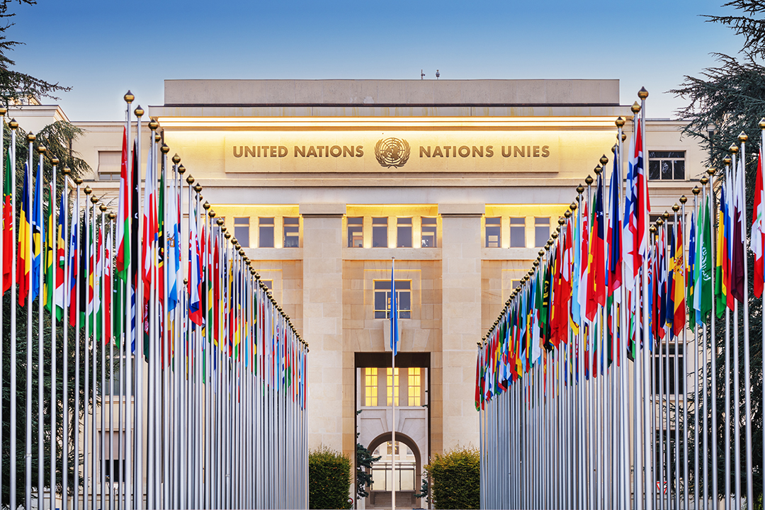 Palais des Nations in Geneva surrounded by international flags, one of the world’s most important centers of diplomacy and global cooperation.