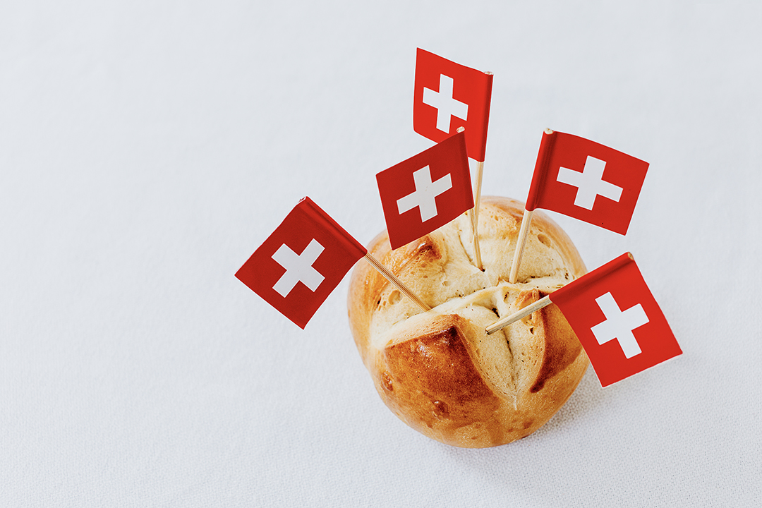 Traditional Swiss bread decorated with Swiss flags representing Swiss culinary culture and national identity.