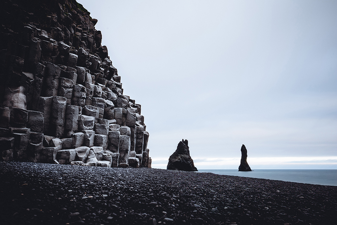 Črna peščena plaža Reynisfjara z bazaltnimi klifi in morskimi skalami ob južni obali Islandije ustvarja eno najbolj dramatičnih pokrajin v državi.